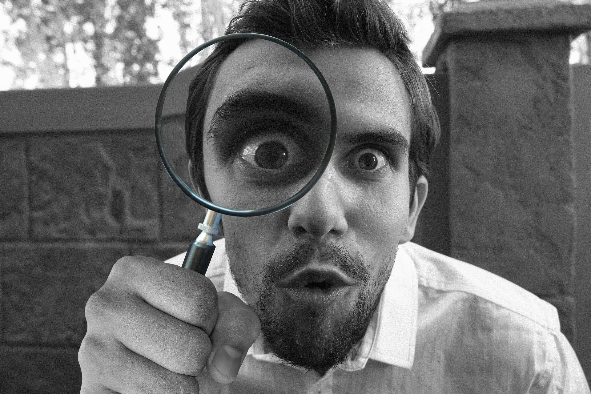 Homme avec une loupe regardant les offres d'abonnement culturel proposé par le bazar culturel
